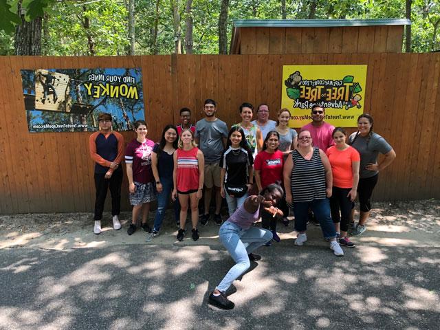 Students standing in front of brown fence at the Zoo